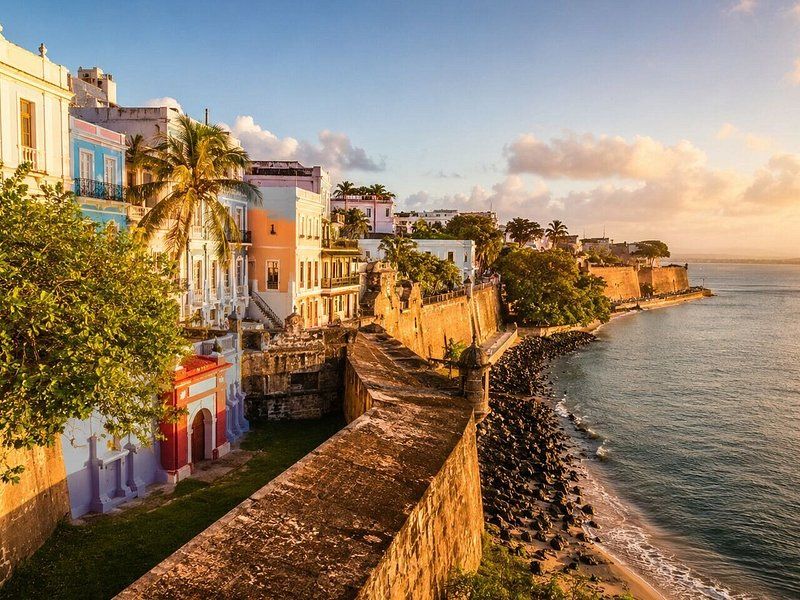 The old city wall of San Juan running down to the sea at sunset